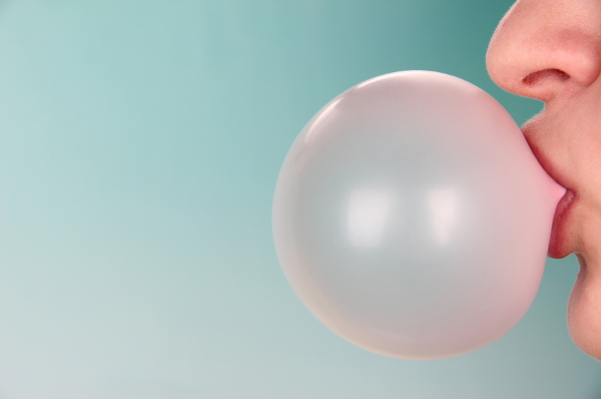 Person-doing-bubble-with-chewing-gum-on-bright-background